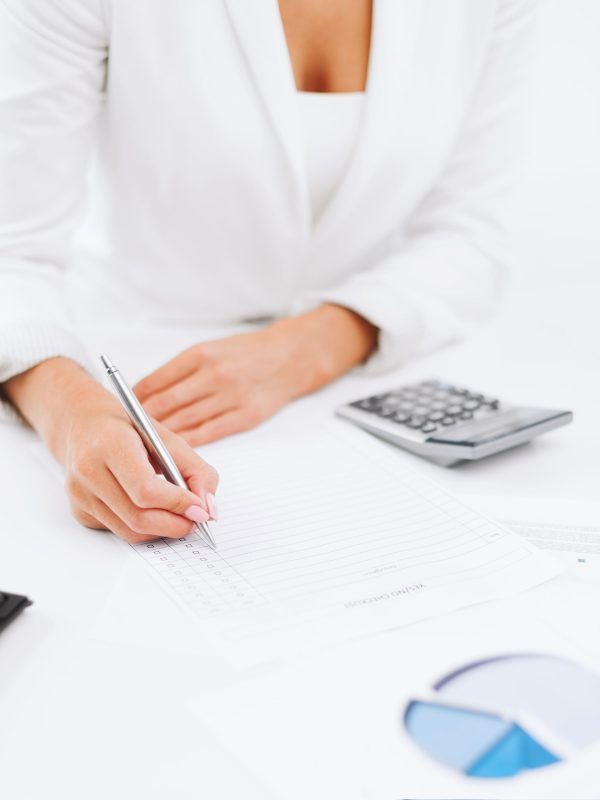 office, business, tax, accounting concept - businesswoman working with calculator in office